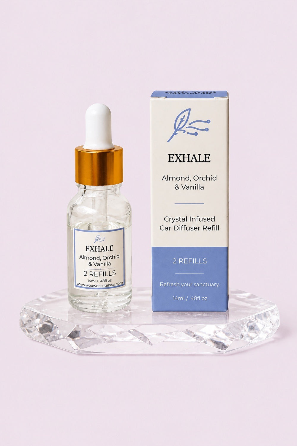 EXHALE refill dropper bottle beside its blue box on a crystal stand, against a soft pink background
